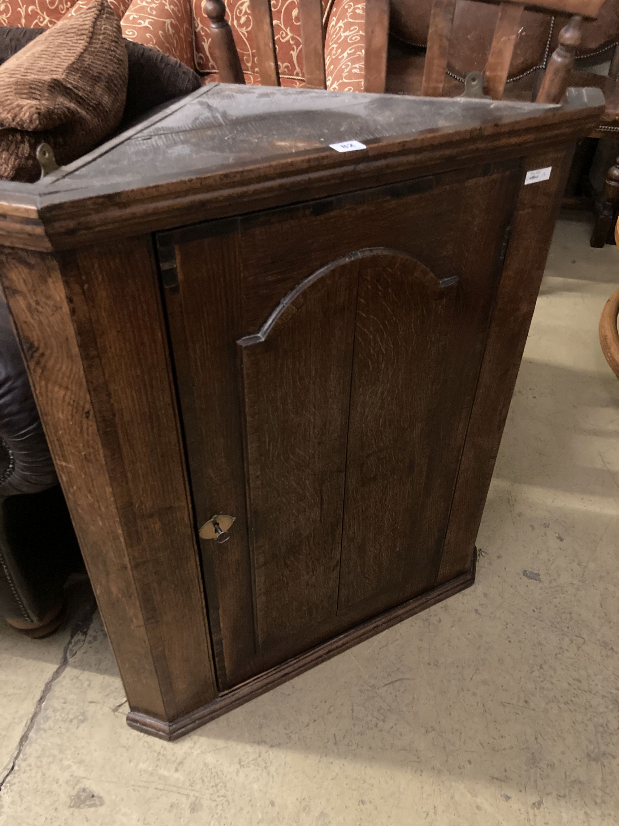 A George III oak hanging corner cabinet, width 77cm, depth 42cm, height 93cm